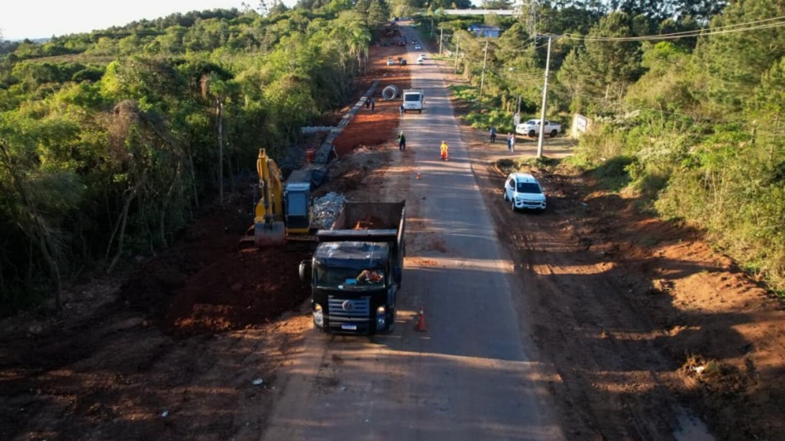 Vista aérea das obras de duplicação na Estrada Caminho do Meio, cercada por vegetação